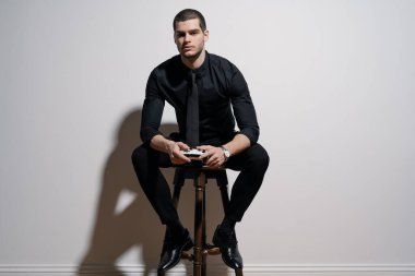 Siyah gömlekli ve siyah takım elbiseli genç yakışıklı iş adamı.