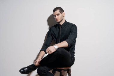 Siyah gömlekli ve siyah takım elbiseli genç yakışıklı iş adamı.