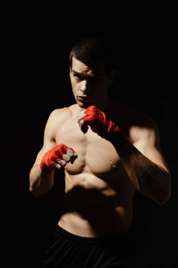 Atletik boksör siyah arka planda kararlılık ve önlem ile yumruk atıyor