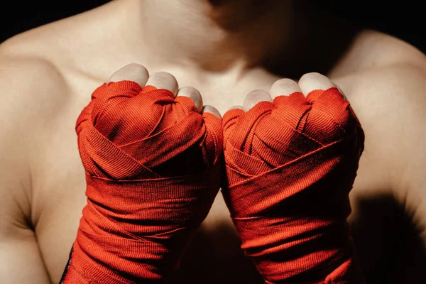 Zamknij ręce boksera w czerwonych bandażach w pobliżu klatki piersiowej — Zdjęcie stockowe