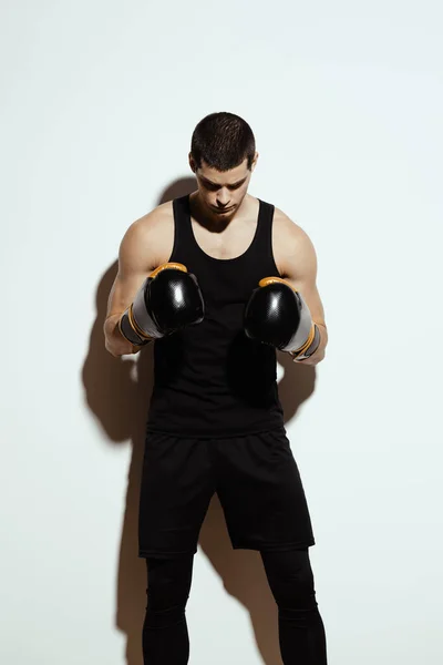 Alto deportista atractivo posando en guantes de boxeo sobre fondo blanco — Foto de Stock