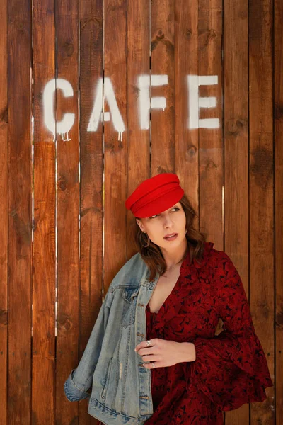 Retrato mujer de moda en gorra roja sobre fondo de madera — Foto de Stock