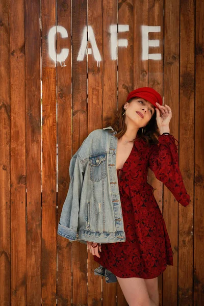 Retrato mujer de moda en gorra roja sobre fondo de madera — Foto de Stock