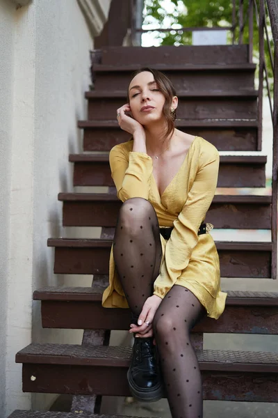 Una joven moderna en vestido amarillo posando en las escaleras — Foto de Stock