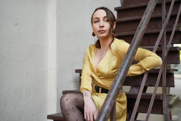 Une jeune femme moderne en robe jaune posant sur les escaliers — Photo
