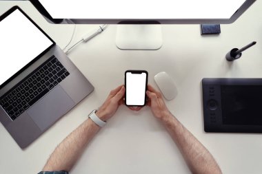 Erkek elleri, beyaz ekranlı siyah bir cep telefonu tutarak yakınlaşıyor.