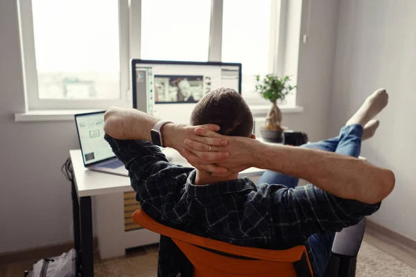 Modern man på hemmakontoret kopplar av med benen på bordet — Stockfoto