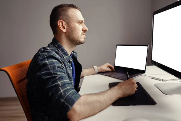 Giovane uomo che lavora con display a penna interattivo e computer — Foto Stock