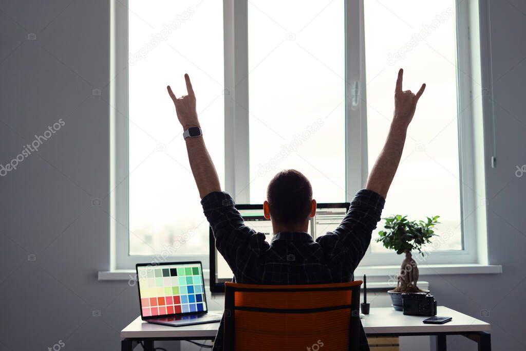 Victorious man celebrating his success in his work place