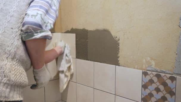 Travailleur carreleur met des carreaux de céramique sur un mur — Video