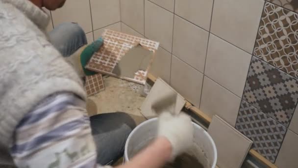 Piastrelle lavoratore mette piastrelle di ceramica su una parete — Video Stock