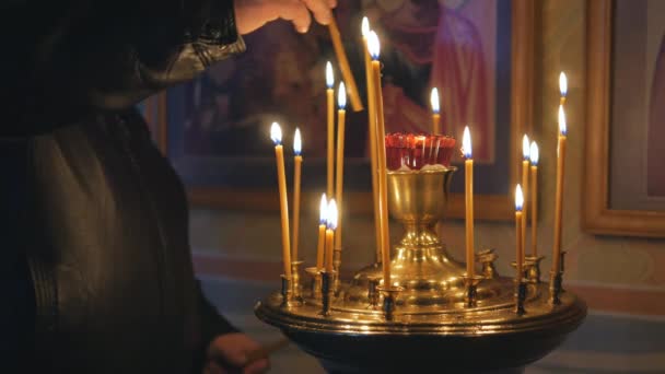 Brandende kaarsen in een orthodoxe kerk. Pictogrammen en gebed. — Stockvideo