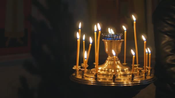 Brennende Kerzen in einer orthodoxen Kirche. Ikonen und Gebet. — Stockvideo