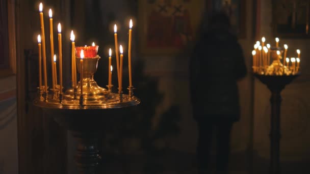 Brennende Kerzen in einer orthodoxen Kirche. Ikonen und Gebet. — Stockvideo