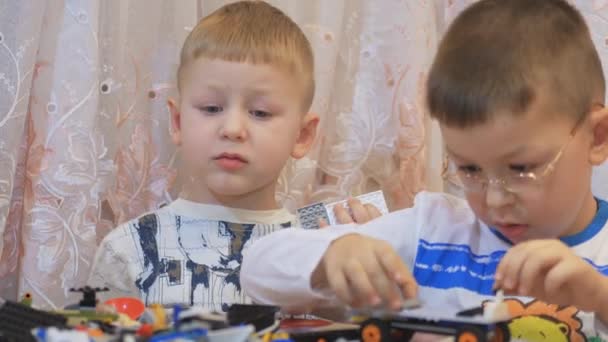 Jeux de table. Enfant jouant jeu intellectuel, recueille le concepteur, sur la table. Gros plan — Video