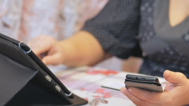 Femme au foyer fait des opérations bancaires en ligne via smartphone et tablette carte de crédit dans la vie à la maison . — Video