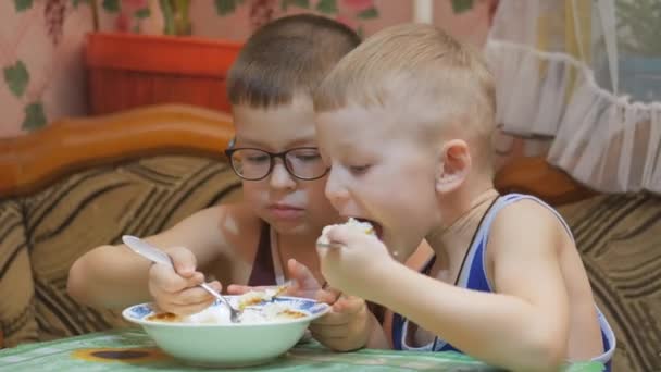 Дети едят с аппетитом за столом . — стоковое видео