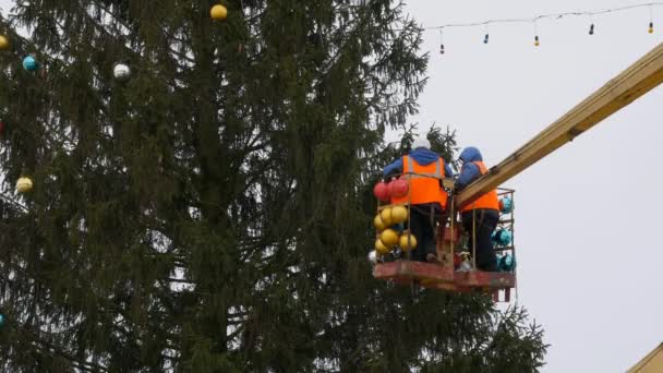 在机械手的摇篮里工人装饰圣诞树 — 图库视频影像