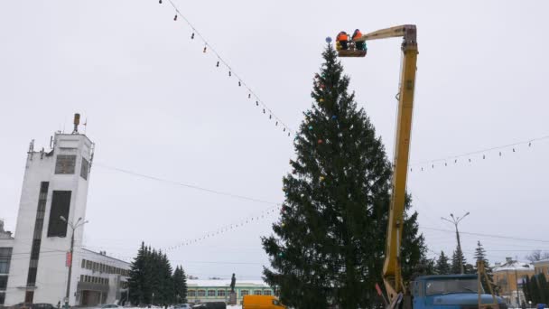 Pracovník v kolébce manipulátor zdobí vánoční strom — Stock video