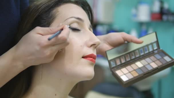 Maquillador haciendo un maquillaje de modelos en el salón — Vídeo de stock
