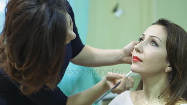 Maquillador haciendo un maquillaje de modelos en el salón — Vídeos de Stock
