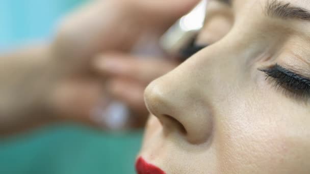 Гример делает макияж моделей в салоне — стоковое видео