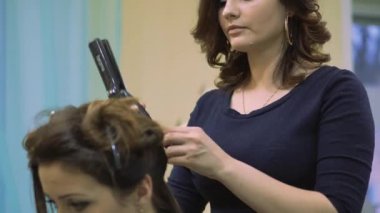Kuaför Saç salonu güzel kadın saç düzleştirici kullanarak. Dalgalanma curling