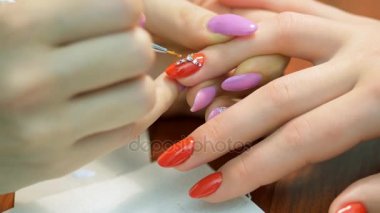 Kız çivi rhinestones süsle. Tasarım rhinestones closeup ile tırnak. Manikürcü işleri.