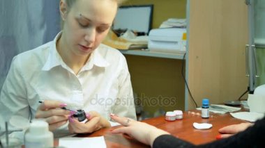 Kız çivi rhinestones süsle. Tasarım rhinestones closeup ile tırnak. Manikürcü işleri.