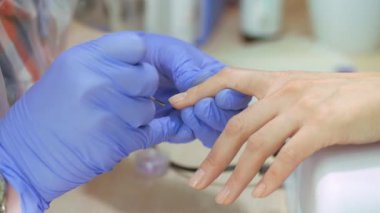 Donanım manikür, yakın çekim, tırnak bakım Güzellik Salonu güzel kadın. Vernik ile manikür. Tırnak tedavi. Manikürcüler çalışma.