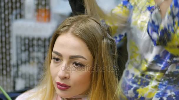 Barbier, teinture pour cheveux, blonde assise dans le salon de beauté. Coiffeur teindre les cheveux . — Video