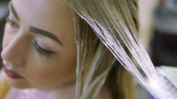 Stylist Studio skönhet orsaka hårfärgningsmedel på blonda slingor. Närbild — Stockvideo
