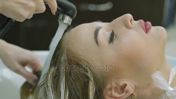Péče o vlasy v moderních lázních. žena s vlasy umýt kadeřník v kadeřnictví. Žena, mytí vlasů v Spa.Spa procedury, salon krásy. Barber myje hlavu krásnou dívku blondýna — Stock video