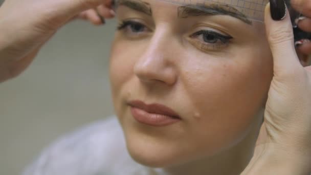 在油漆，眉毛化妆坐从主映像制造商美容院的头发的年轻女子超高清 — 图库视频影像