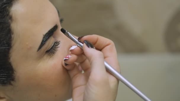 Mujer joven con el pelo en la pintura, para el maquillaje de cejas sentado desde el maestro fabricante de imágenes salón de belleza ultra HD — Vídeos de Stock