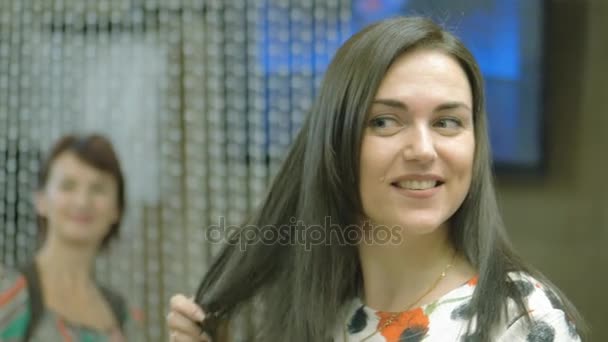 Eine Frau mit langen dunklen Haaren in einem Schönheitssalon, eine dankbare Kundin nach den Eingriffen im Schönheitssalon — Stockvideo