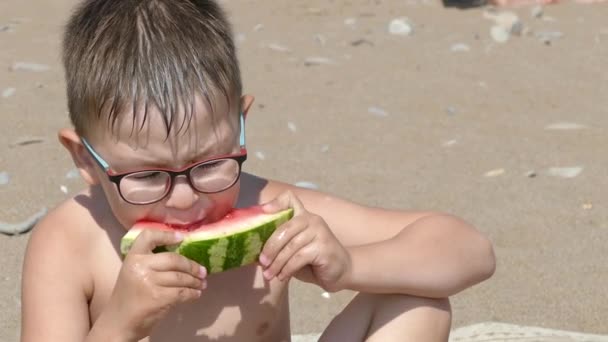 男孩在沙滩上吃西瓜。慢动作 — 图库视频影像