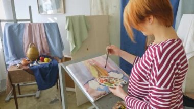 Genç bir sanatçı bir sanat atölyesi olarak suluboya doğada bir natürmort çizer.