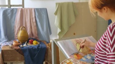 Genç bir sanatçı bir sanat atölyesi olarak suluboya doğada bir natürmort çizer.