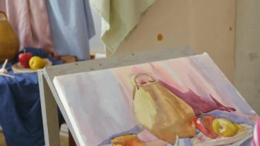 Genç bir sanatçı bir sanat atölyesi olarak suluboya doğada bir natürmort çizer.