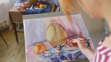Genç bir sanatçı bir sanat atölyesi olarak suluboya doğada bir natürmort çizer.