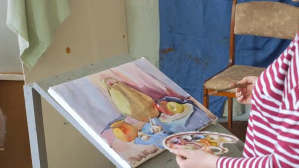 Un jeune artiste dans un atelier d'art dessine une nature morte dans l'aquarelle . — Video