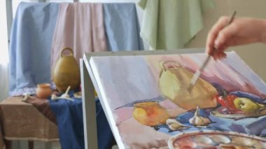Genç bir sanatçı bir sanat atölyesi olarak suluboya doğada bir natürmort çizer.