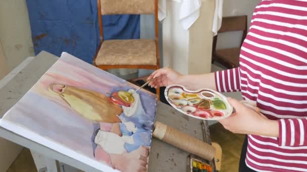 En ung konstnär i en konstverkstaden drar ett stilleben från naturen i akvarell. — Stockvideo
