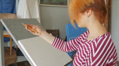 Genç bir sanatçı bir sanat atölyesi olarak kalem doğada bir natürmort bir eskiz çizer.