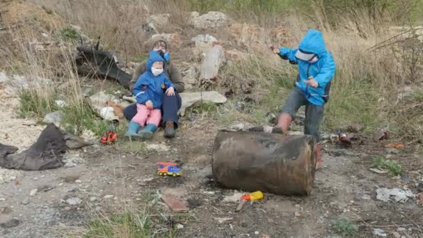 Ecología. Vertedero, Los niños pequeños en el área contaminada junto con su madre viven en el futuro . — Vídeos de Stock