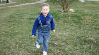 Küçük çocuk fotoğraf makinesi için çalışan ve mutlu yüzler oluşturur