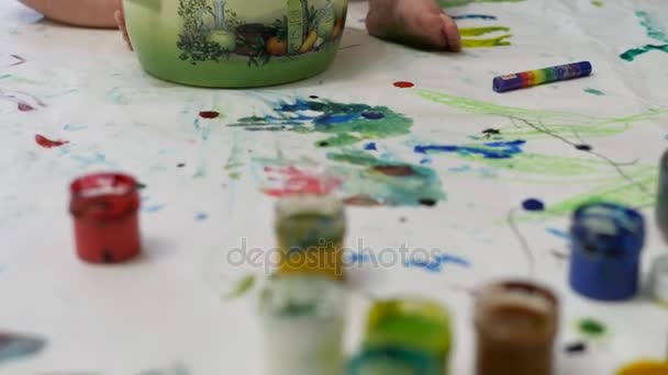 Маленькая девочка рисует со своим братом за столом в доме . — стоковое видео