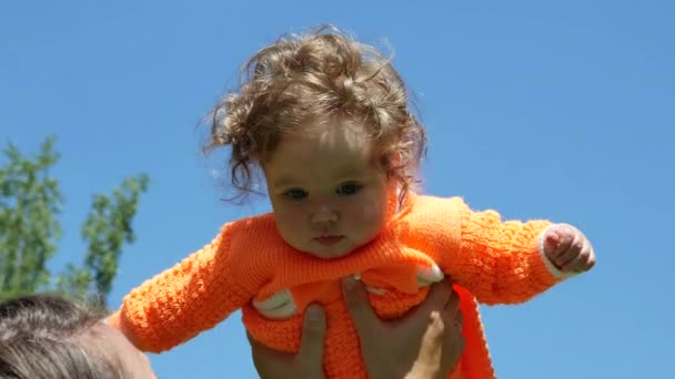 Bambino felice in una radura di primavera in denti di leone con la sua famiglia . — Video Stock