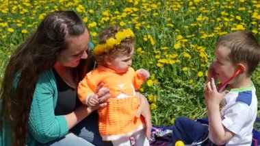 Bir bahar glade içinde dandelions ailesiyle birlikte mutlu çocuk.
